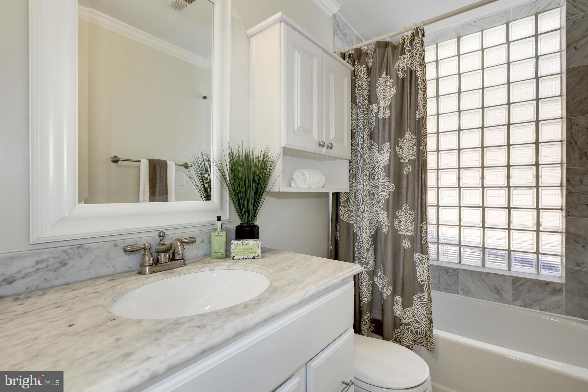 1806 Belmont Road Northwest, Unit 3 Washington, DC 20009 - Photo 13 of 21 a bathroom with a granite countertop sink toilet a mirror and shower