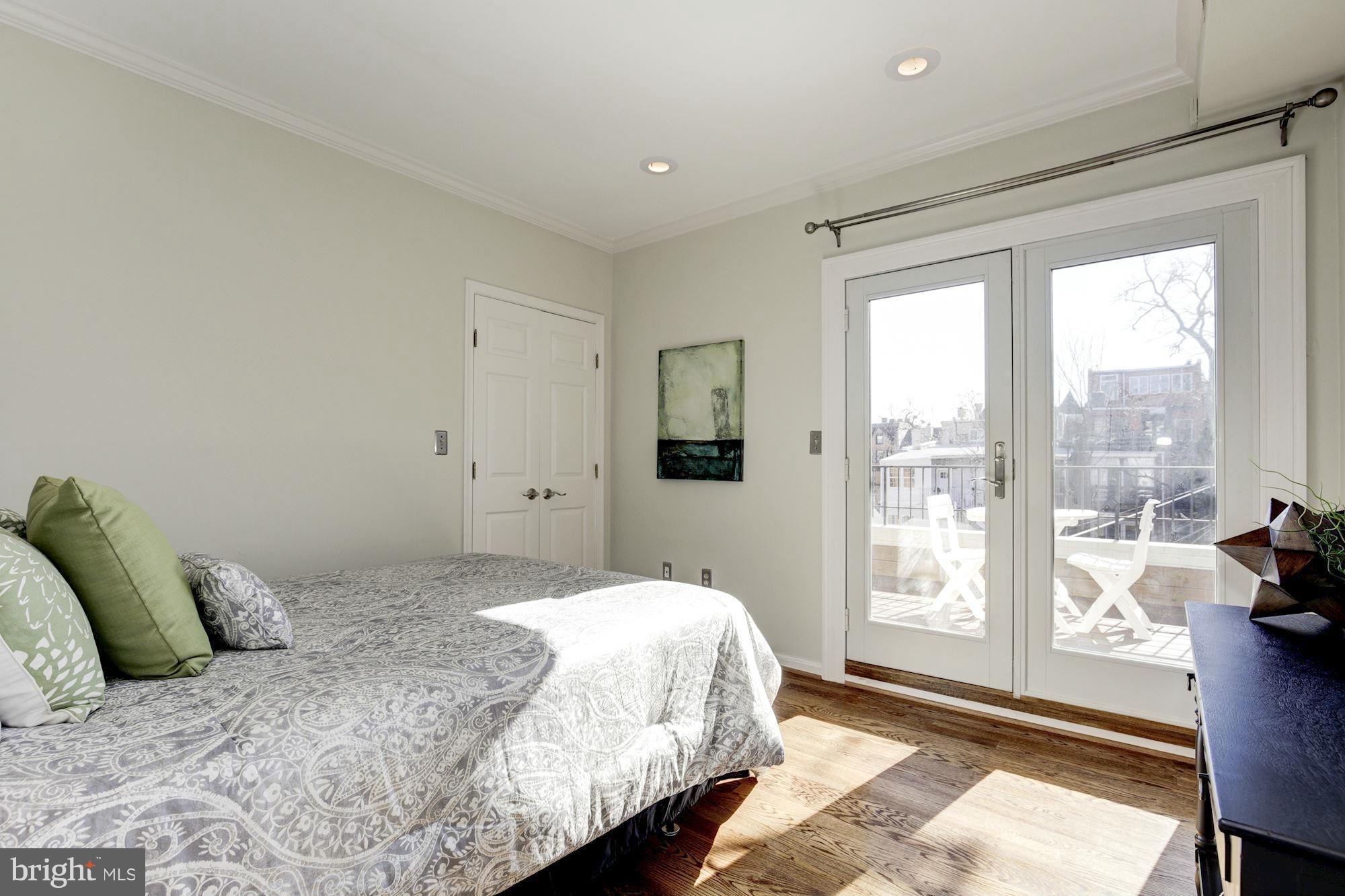 1806 Belmont Road Northwest, Unit 3 Washington, DC 20009 - Photo 14 of 21 a bedroom with a bed and a large window with outer view