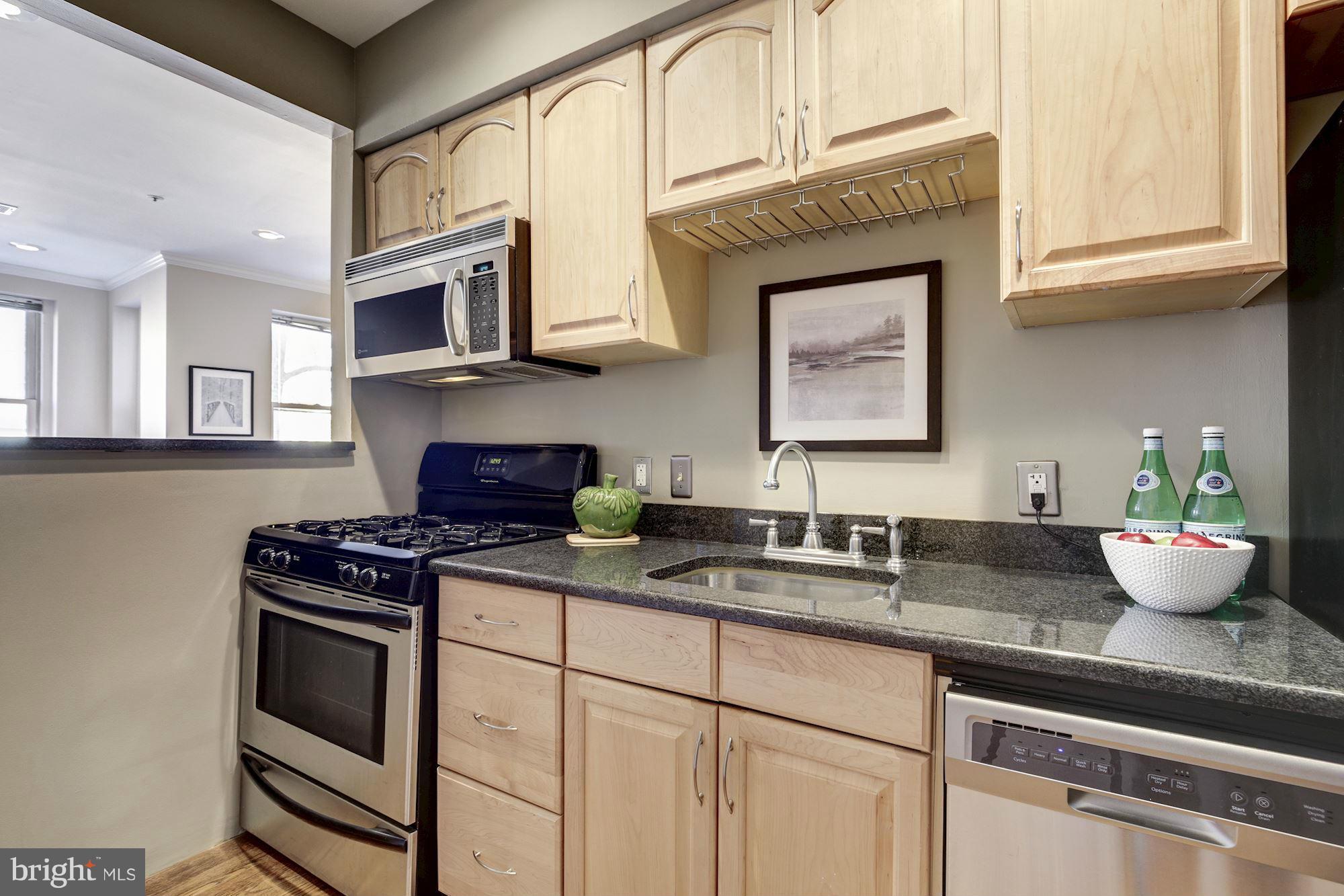 1806 Belmont Road Northwest, Unit 3 Washington, DC 20009 - Photo 8 of 21 a kitchen with stainless steel appliances granite countertop a stove a microwave and cabinets