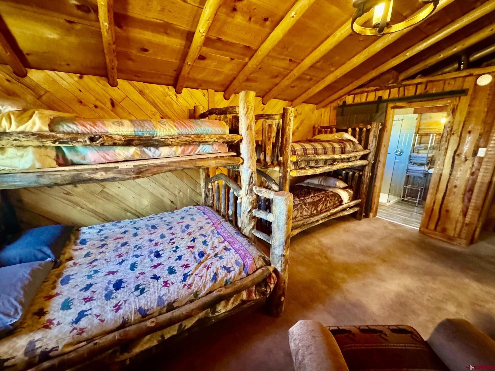 16 Arellano Road, Unit TRES CUERDAS LODGE Amalia, NM 87512 - Photo 36 of 45 a bedroom with bed and a walk in closet