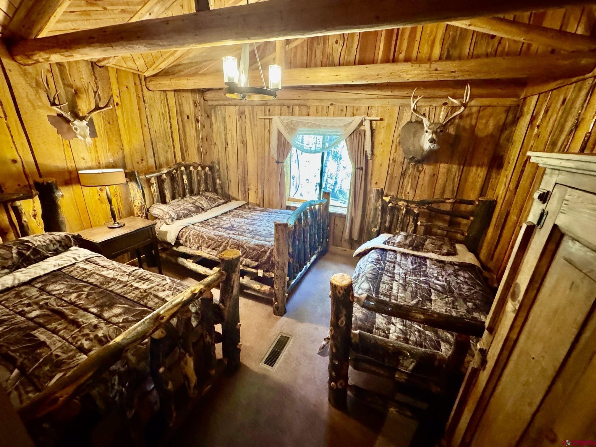 16 Arellano Road, Unit TRES CUERDAS LODGE Amalia, NM 87512 - Photo 37 of 45 a bedroom with furniture and a window