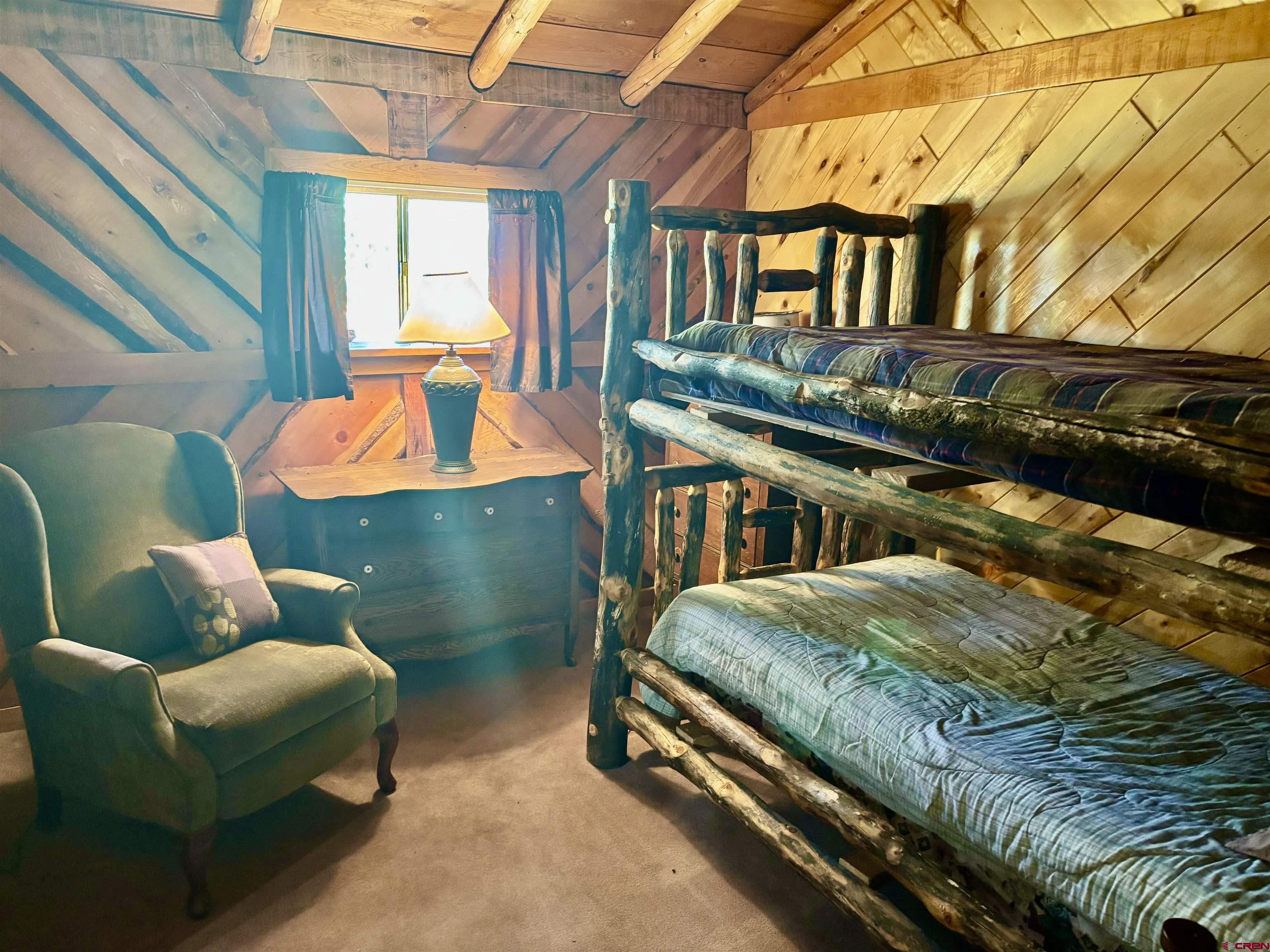 16 Arellano Road, Unit TRES CUERDAS LODGE Amalia, NM 87512 - Photo 38 of 45 a bedroom with furniture and a window