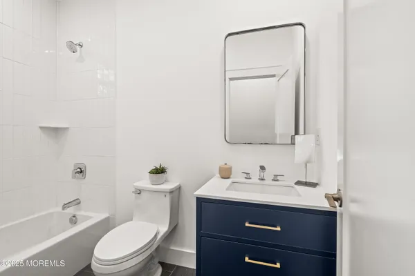 a bathroom with a toilet a sink a tub and mirror