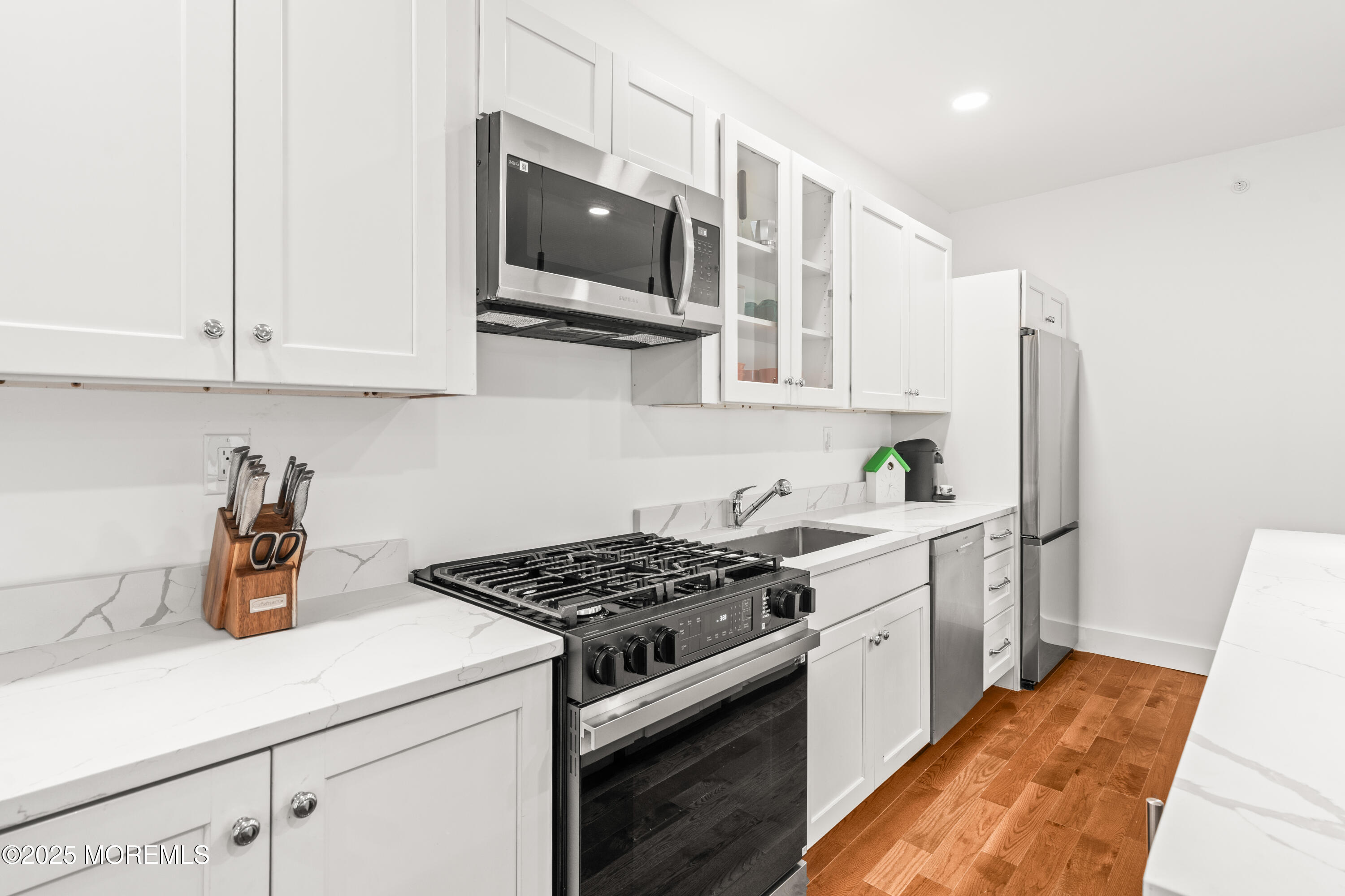 73 3rd Avenue, Unit B Atlantic Highlands, NJ 07716 - Photo 7 of 9 a kitchen with stainless steel appliances a white stove top oven a sink a refrigerator and cabinets