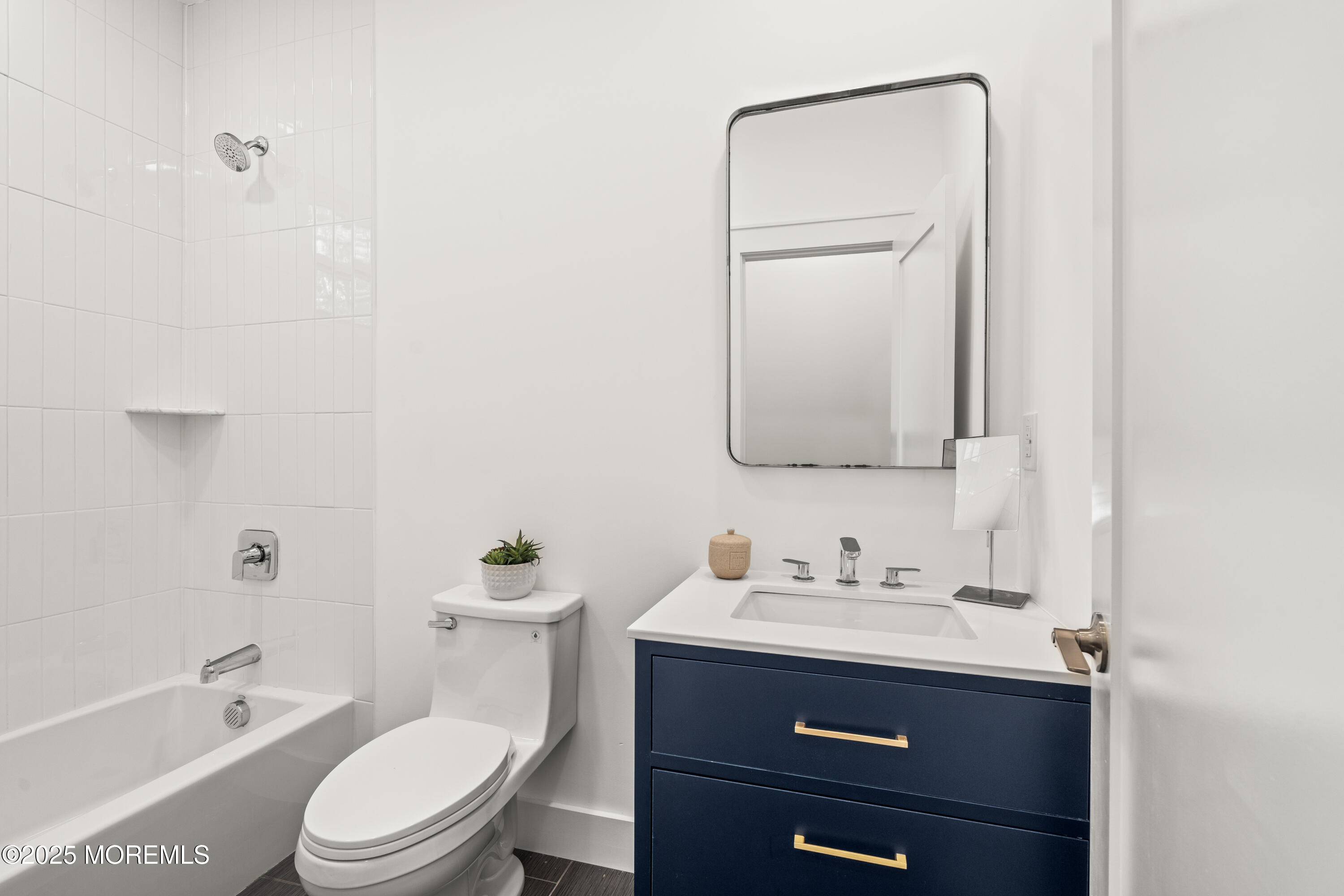 73 3rd Avenue, Unit B Atlantic Highlands, NJ 07716 - Photo 9 of 9 a bathroom with a toilet a sink a tub and mirror