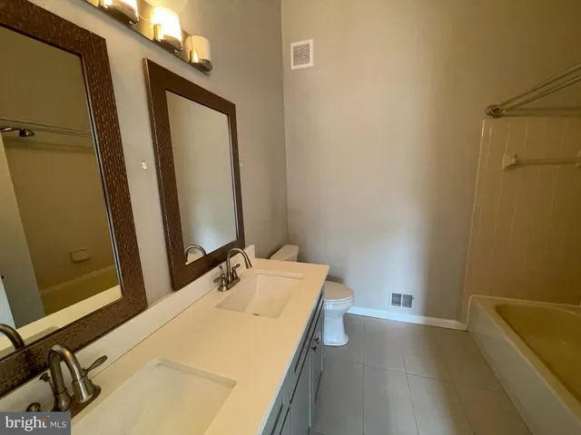 a bathroom with a tub sink and mirror