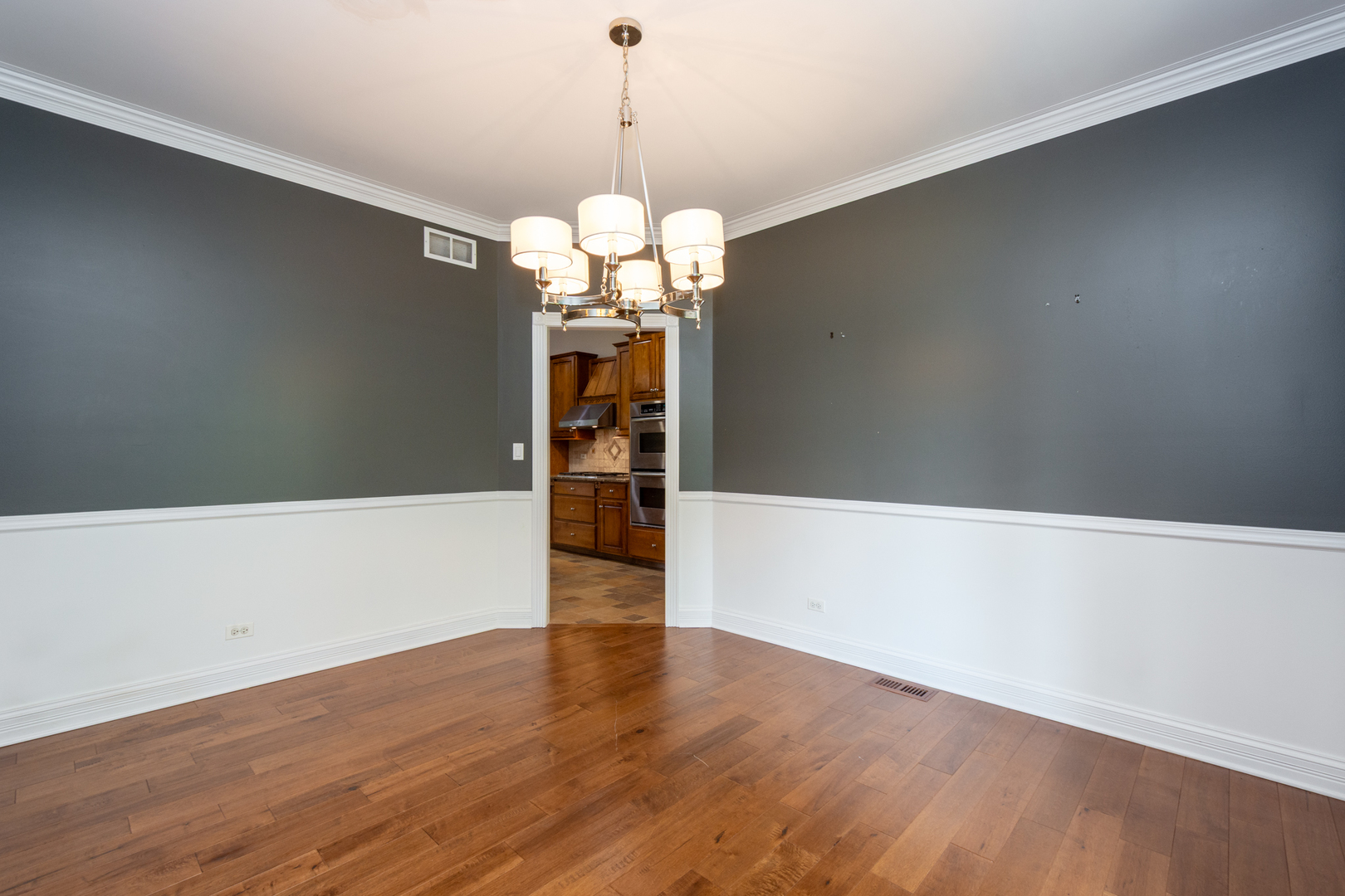 10303 Fox Bluff Lane Spring Grove, IL 60081 - Photo 13 of 44 a view of a room with wooden floor and chandelier