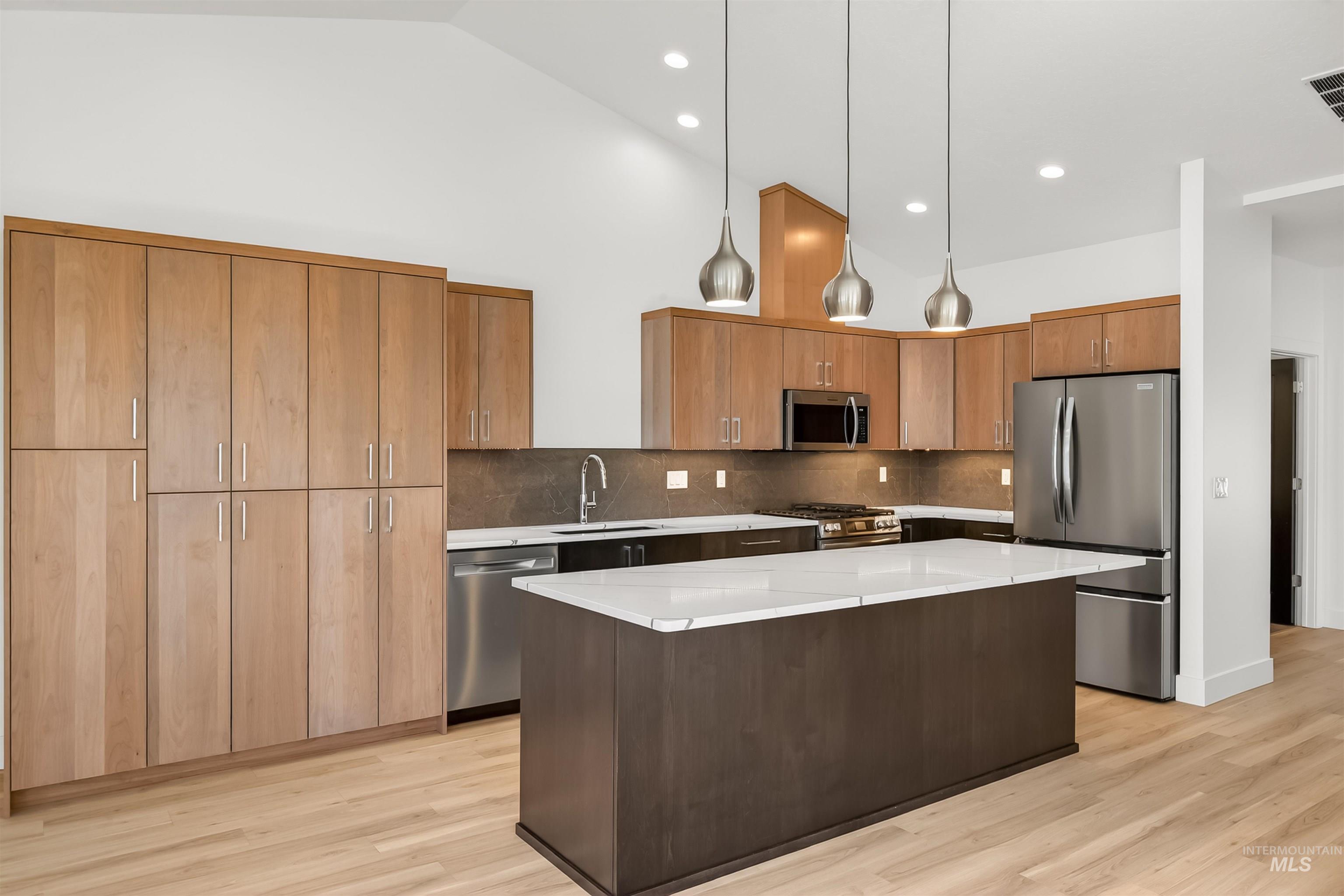 3710 22nd Street Lewiston, ID 83501 - Photo 22 of 36 Kitchen with a center island, stainless steel appliances, light wood finished floors, light stone countertops, and lofted ceiling