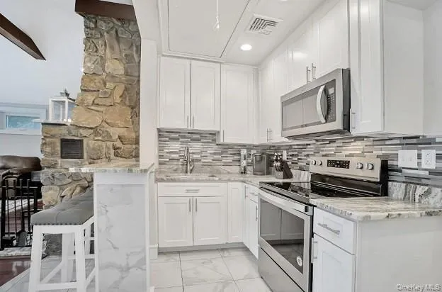 a kitchen with cabinets appliances a sink and a counter top space