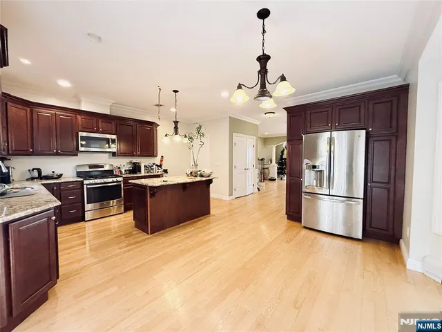 a kitchen with stainless steel appliances granite countertop a refrigerator a stove top oven a sink and dishwasher