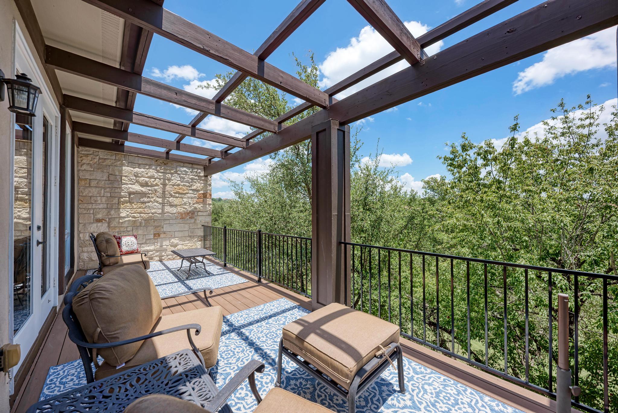 2601 North Quinlan Park Road, Unit 506 Austin, TX 78732 - Photo 32 of 39 An inviting deck with an overhead pergola provides a serene outdoor living space.