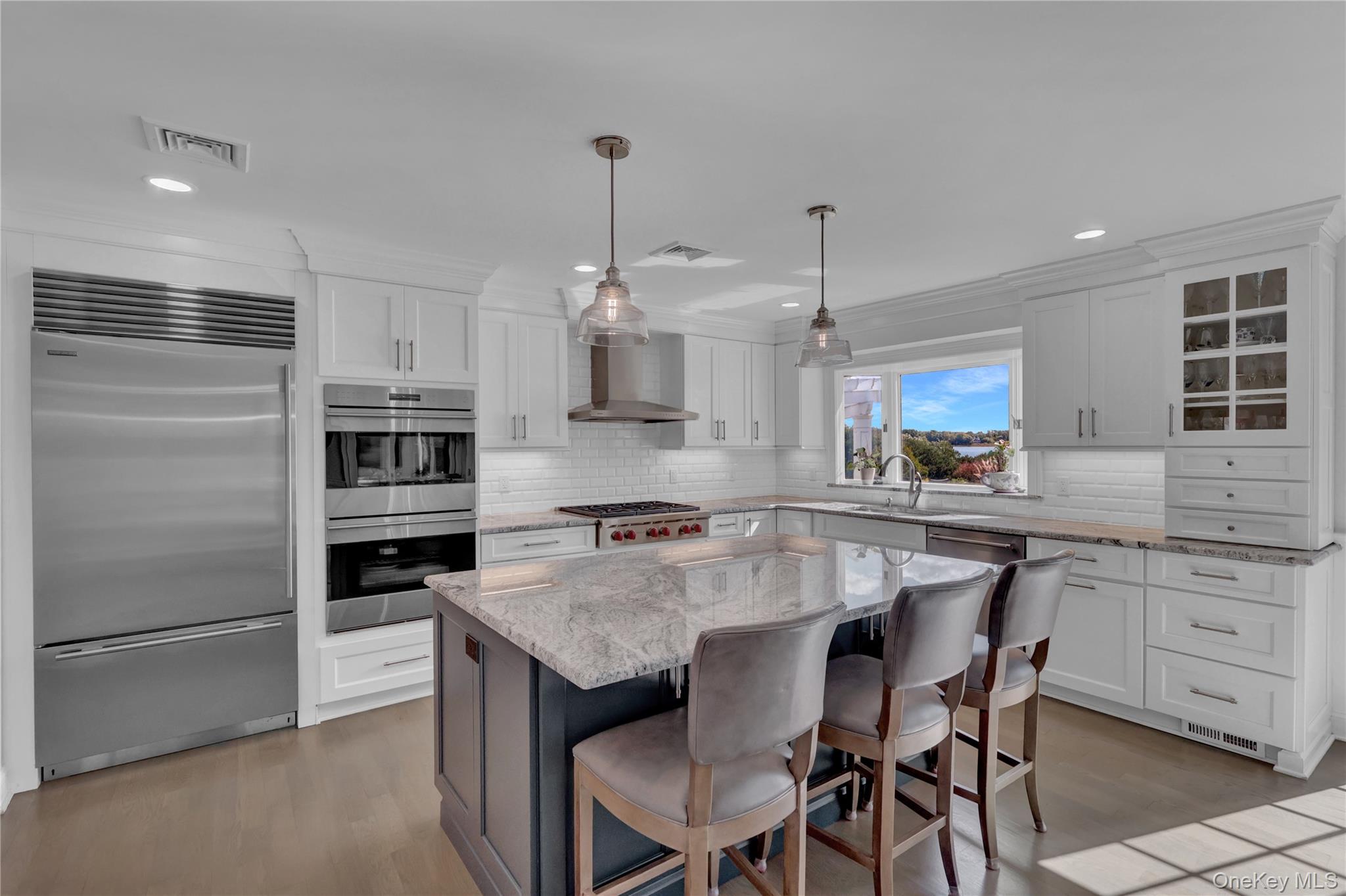 111 Old Field Road Setauket, NY 11733 - Photo 11 of 47 a kitchen with kitchen island granite countertop a table chairs stainless steel appliances and cabinets