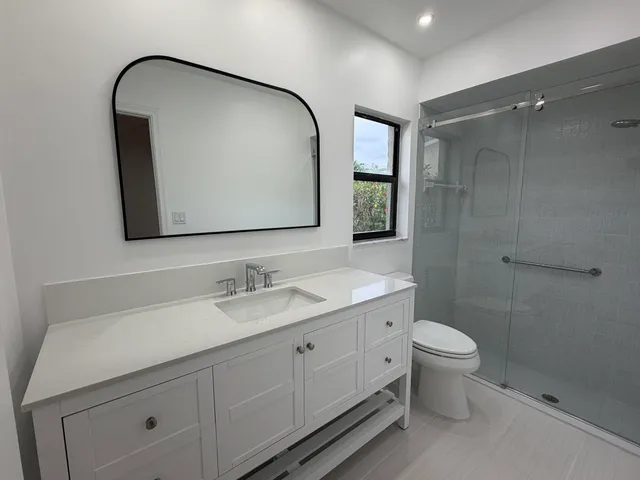 a bathroom with a toilet a sink a vanity and mirror