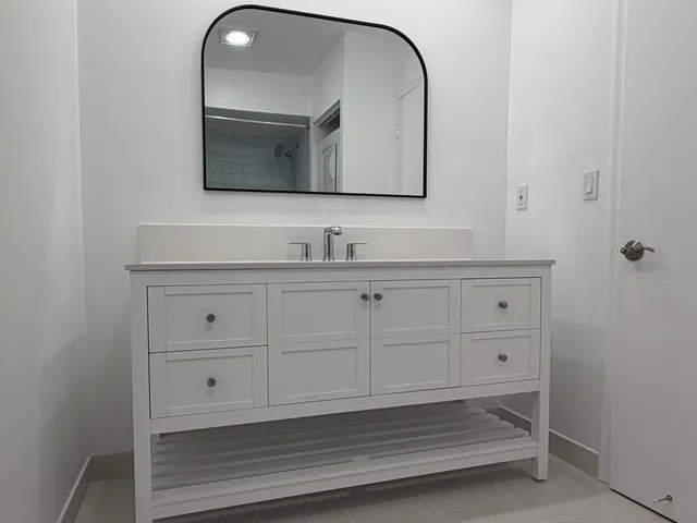 a bathroom with a sink vanity and mirror