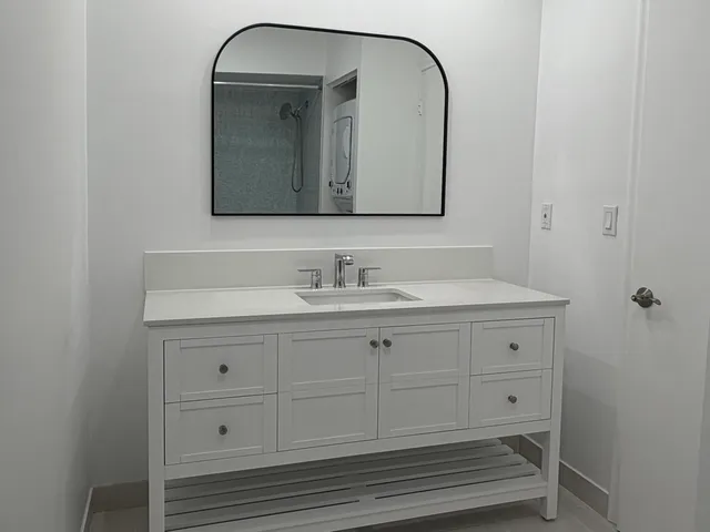 a bathroom with a sink vanity and mirror