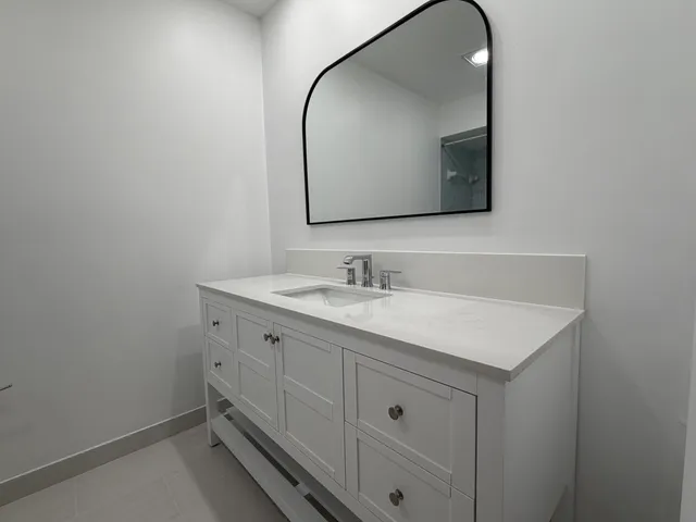 a bathroom with a sink vanity and a mirror