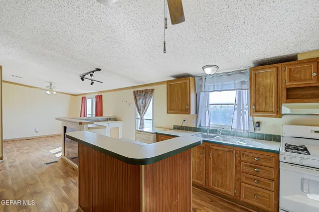 a kitchen with stainless steel appliances kitchen island granite countertop a table chairs and a refrigerator