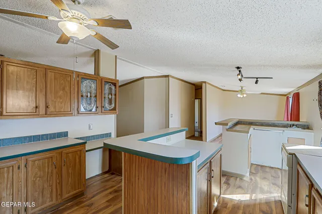 a kitchen with granite countertop a sink stove and refrigerator