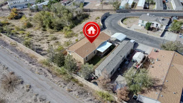 an aerial view of a house with swimming pool and red chairs