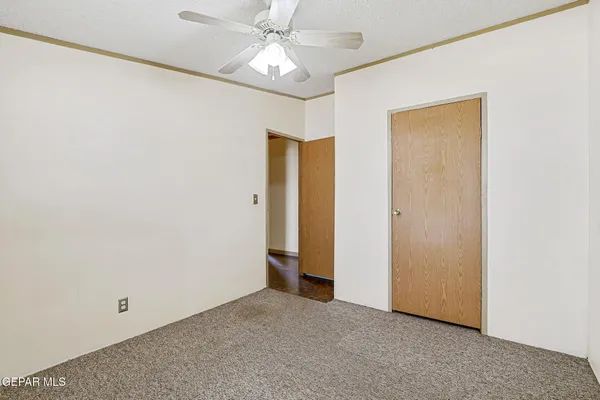 an empty room with a ceiling fan and a window