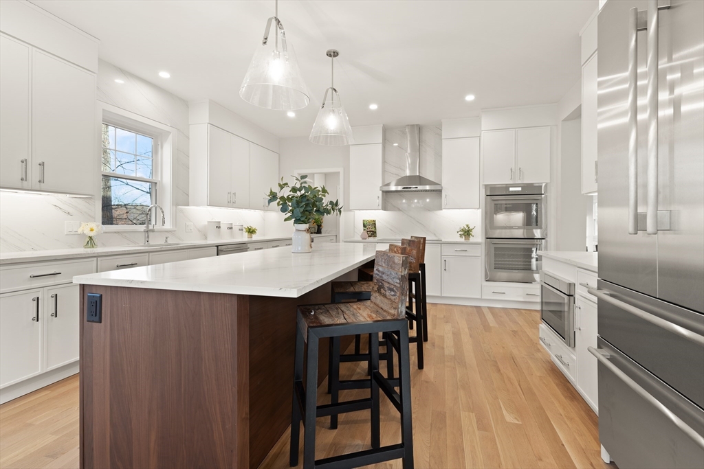 14 Benjamin Road Lexington, MA 02421 - Photo 13 of 35 a kitchen with kitchen island a wooden floor and white stainless steel appliances
