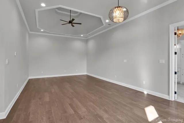 an empty room with wooden floor fireplace and window