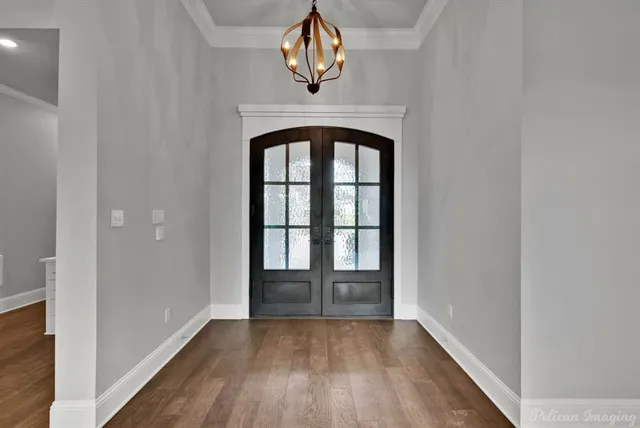 a view of a livingroom with furniture a fireplace wooden floor and windows
