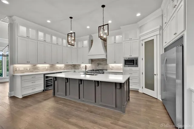 a kitchen with stainless steel appliances granite countertop white cabinets and a stove a oven with white countertops