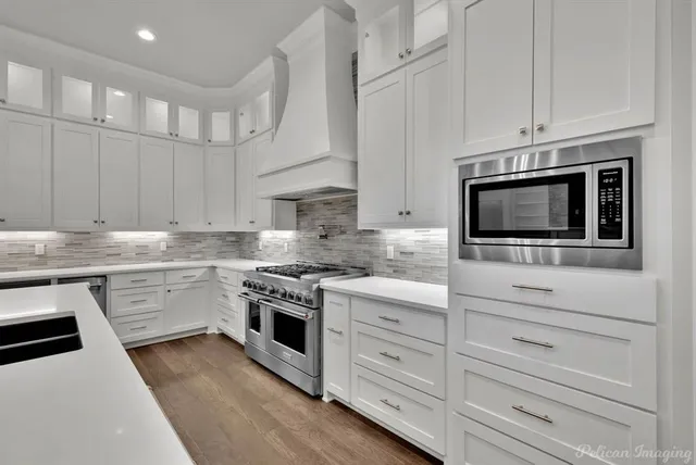 a kitchen with granite countertop a sink stove cabinets and wooden floor