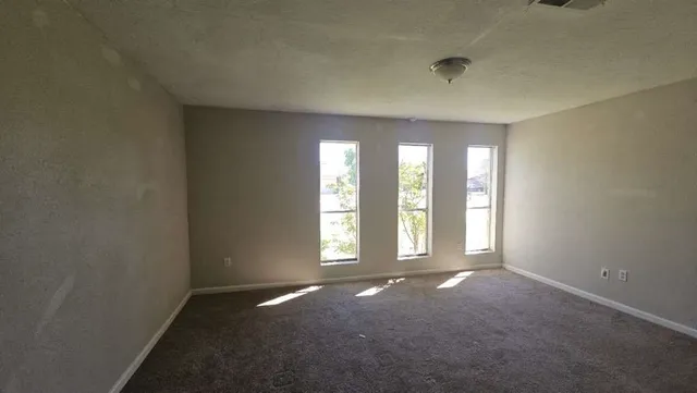 an empty room with windows and closet