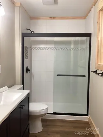 a bathroom with a granite countertop sink mirror vanity and toilet