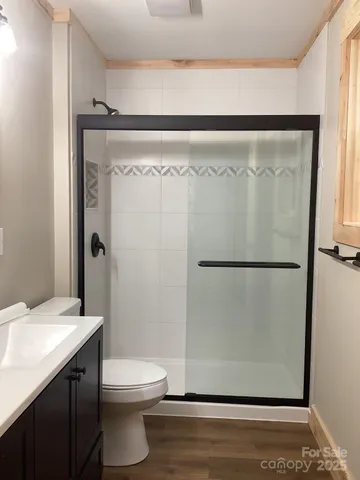 a bathroom with a granite countertop sink mirror vanity and toilet