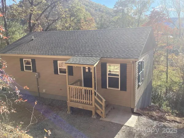 a view of a house with porch and wooden fence