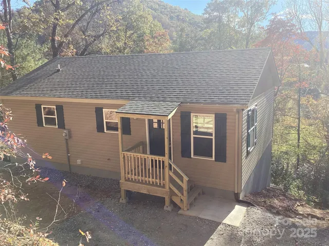 a view of a house with porch and wooden fence
