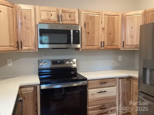 a kitchen with granite countertop a stove and a microwave