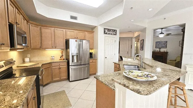 a large kitchen with granite countertop lots of counter space dining table and stainless steel appliances