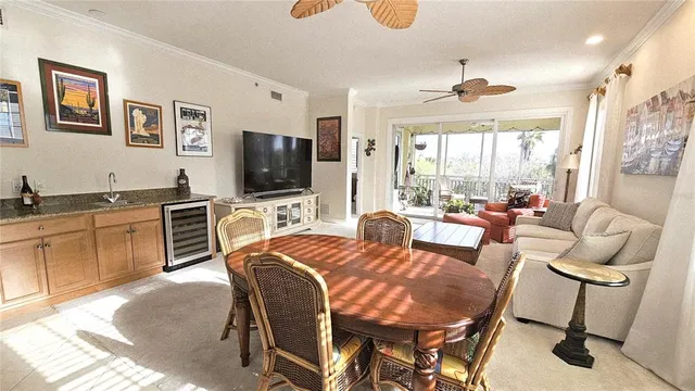 a dining hall with stainless steel appliances granite countertop a stove a dining table and chairs with wooden floor