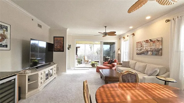 a living room with furniture a chandelier and a large window