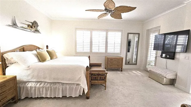 a bedroom with a bed and a flat tv screen on the dresser