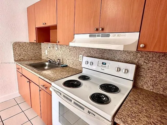 a kitchen with a stove and a white cabinets