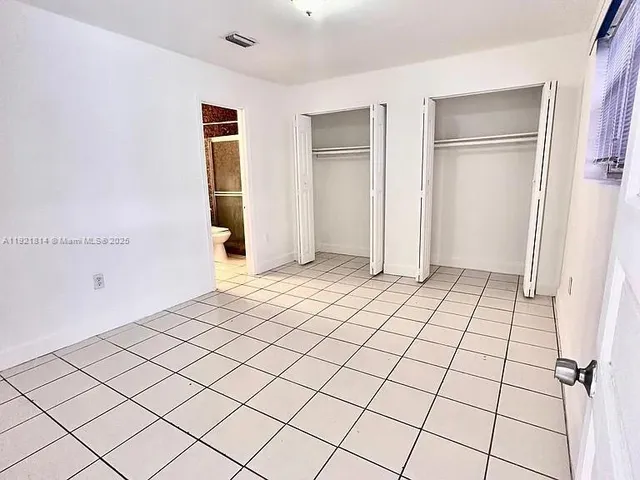 a view of an empty walk in closet with wooden cabinet door