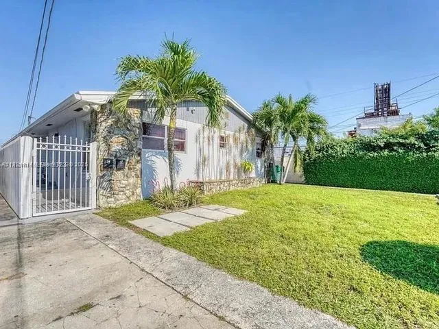 a backyard of a house with lawn chairs and wooden fence