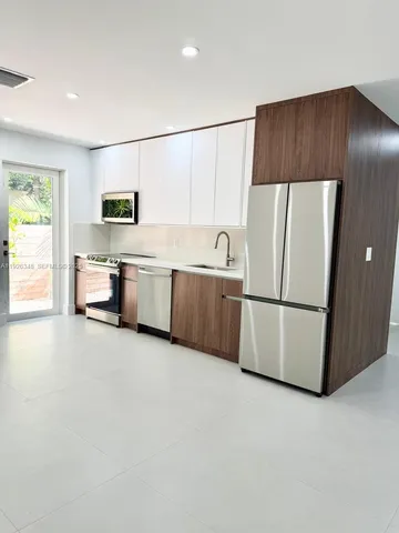 a kitchen with stainless steel appliances a refrigerator a stove a sink and a microwave