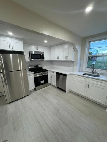 a kitchen with stainless steel appliances a refrigerator sink and microwave