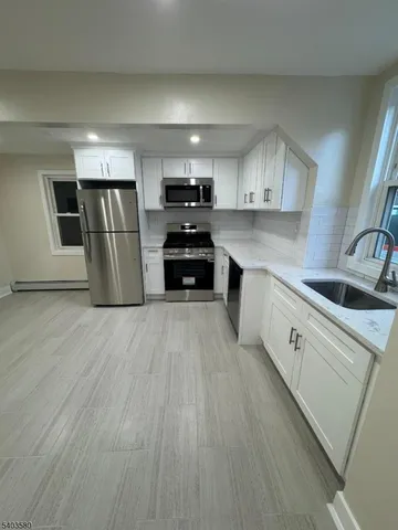 a kitchen with stainless steel appliances a refrigerator sink and microwave