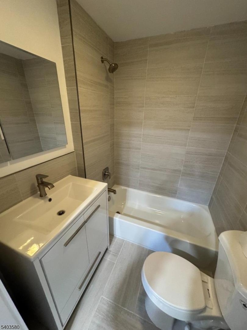 93 Bruen Street Newark, NJ 07105 - Photo 4 of 9 a bathroom with a tub toilet sink mirror and vanity