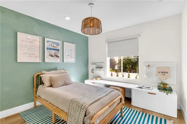 a bedroom with a bed a chandelier and a window