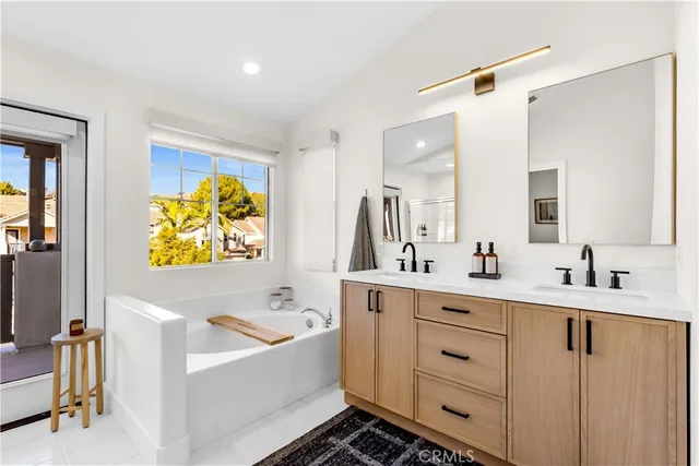 a bathroom with a sink mirror and a bathtub