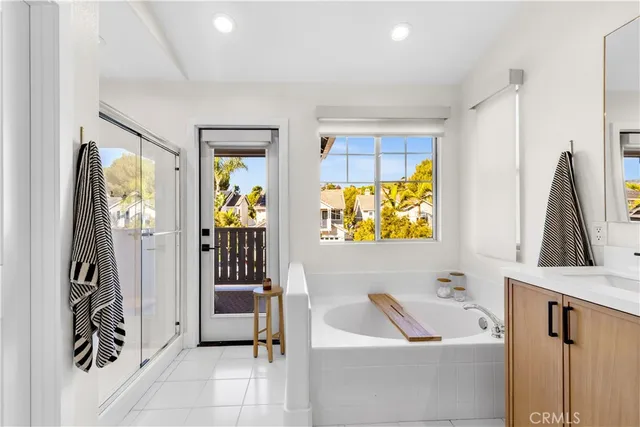 a bathroom with a tub sink and mirror