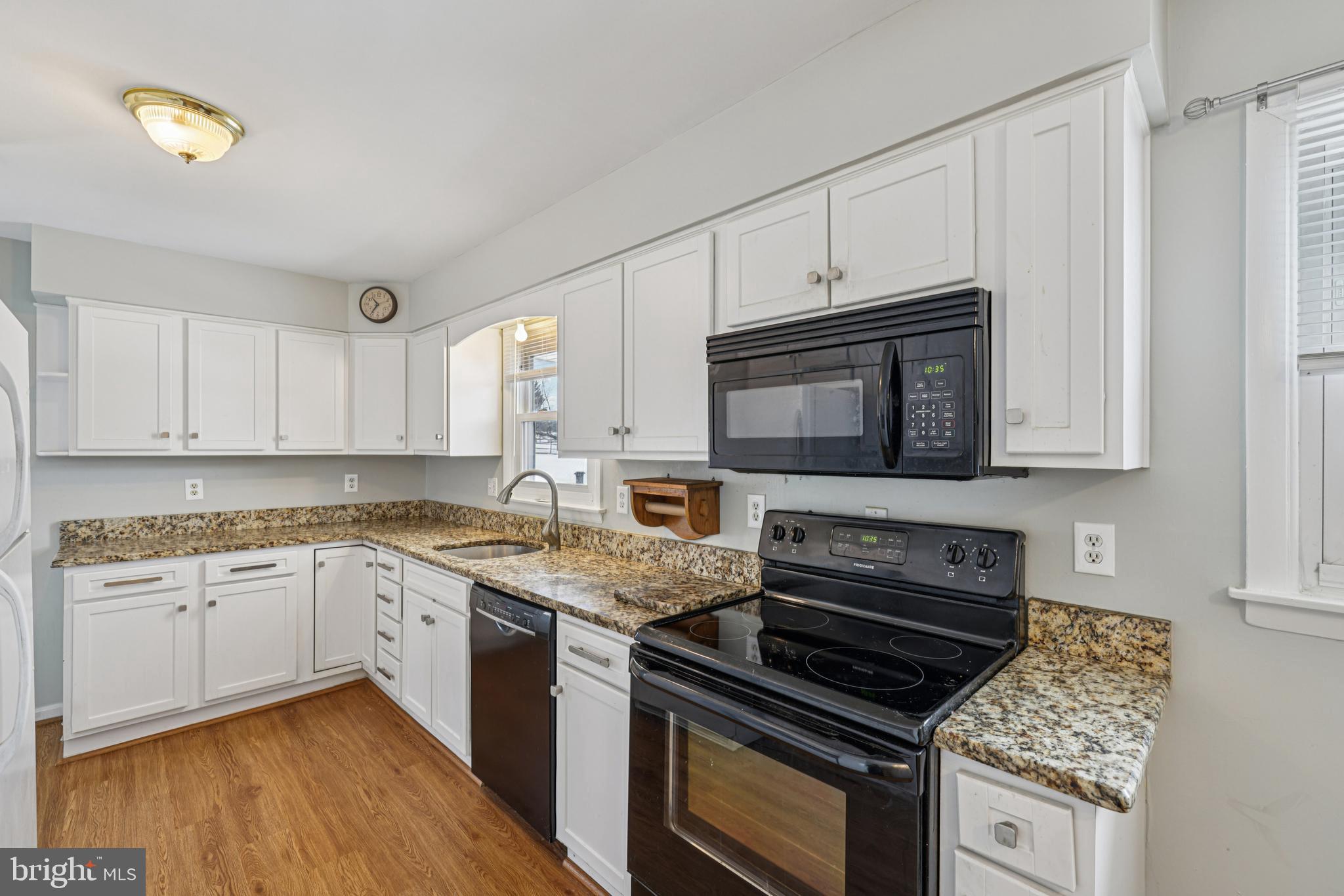 917 Century Street Hampstead, MD 21074 - Photo 13 of 45 a kitchen with granite countertop a stove sink and cabinets